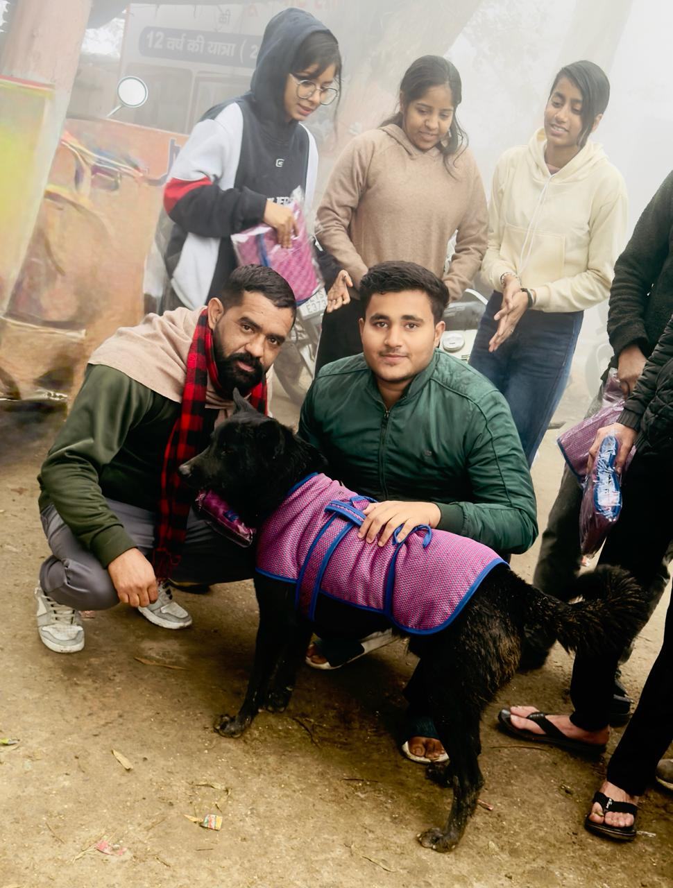 Volunteers helping a dog with winter coat